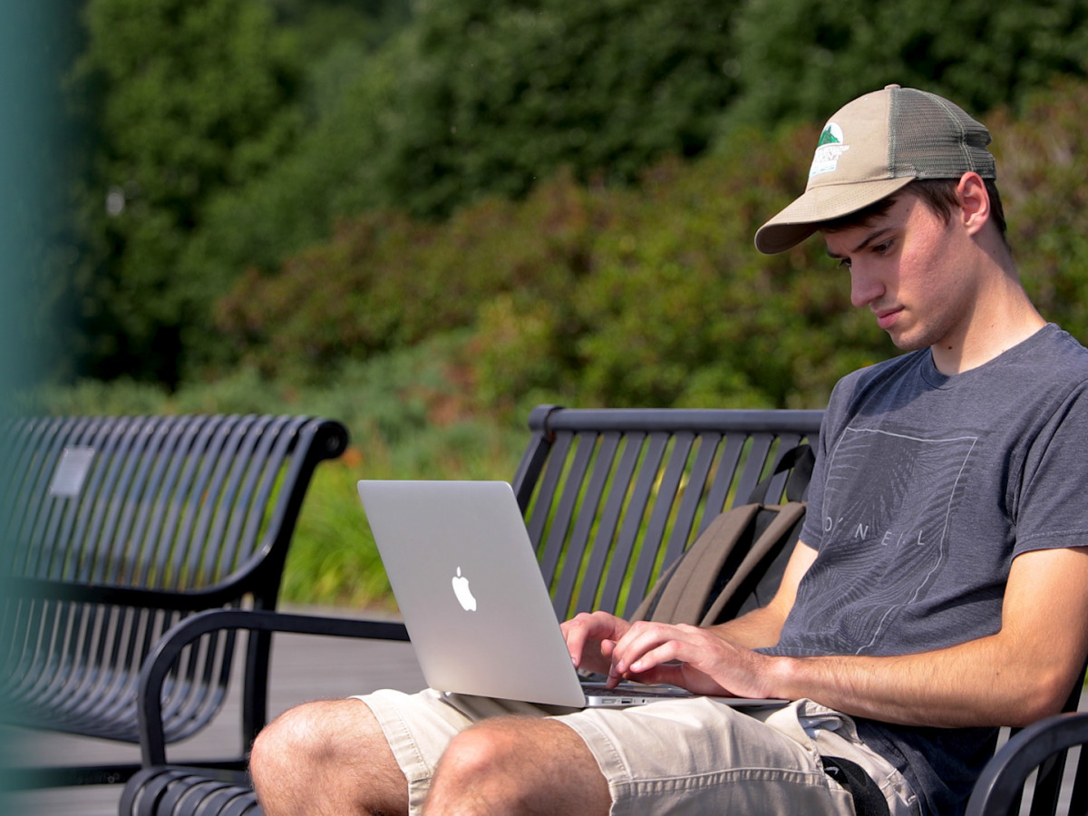 student on laptop outside