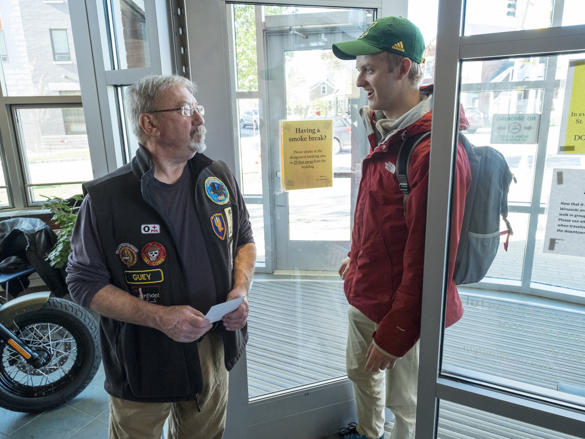 veteran greets student in doorway