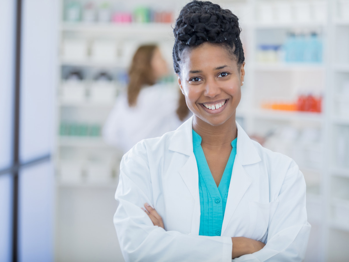 Image of pharmacy technician in front of shelving