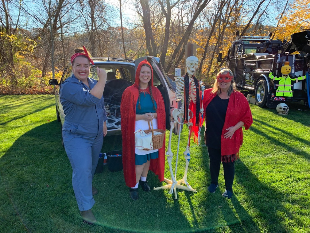 Three staff members dressed up in Halloween costumes at trunk or treat