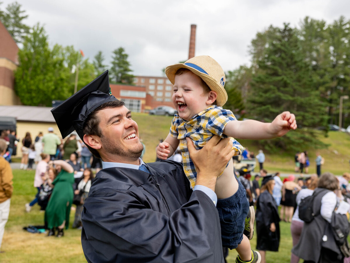 Graduate holding smiling child