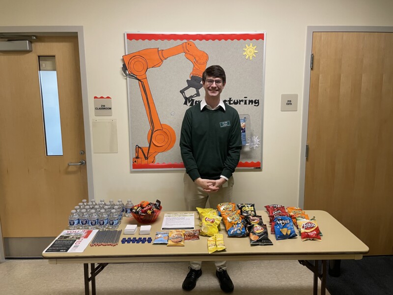 Cody Miller standing behind a table