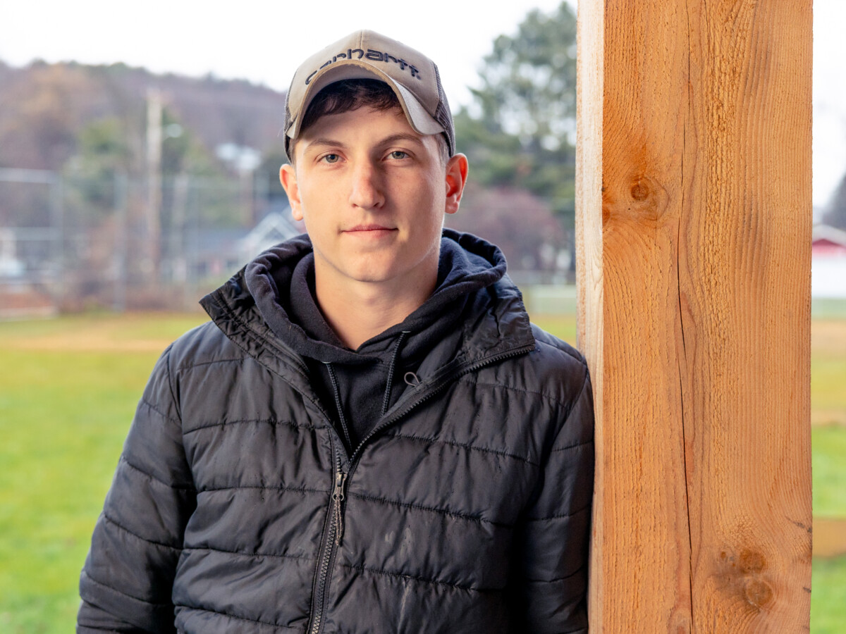 CCV graduate Blake Clark is wearing a black jacket and a baseball hat.