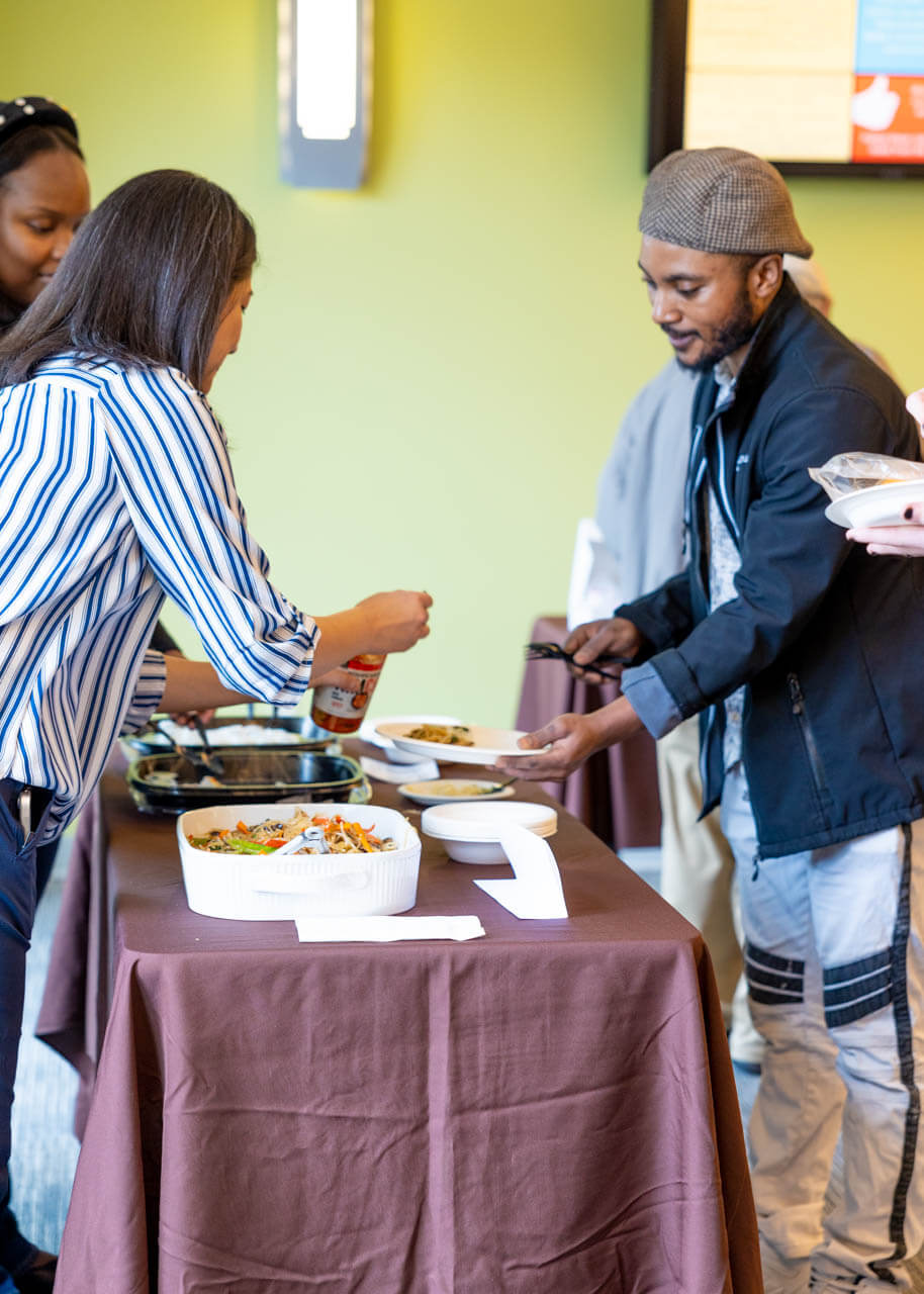 People serving food at the International Food Festival
