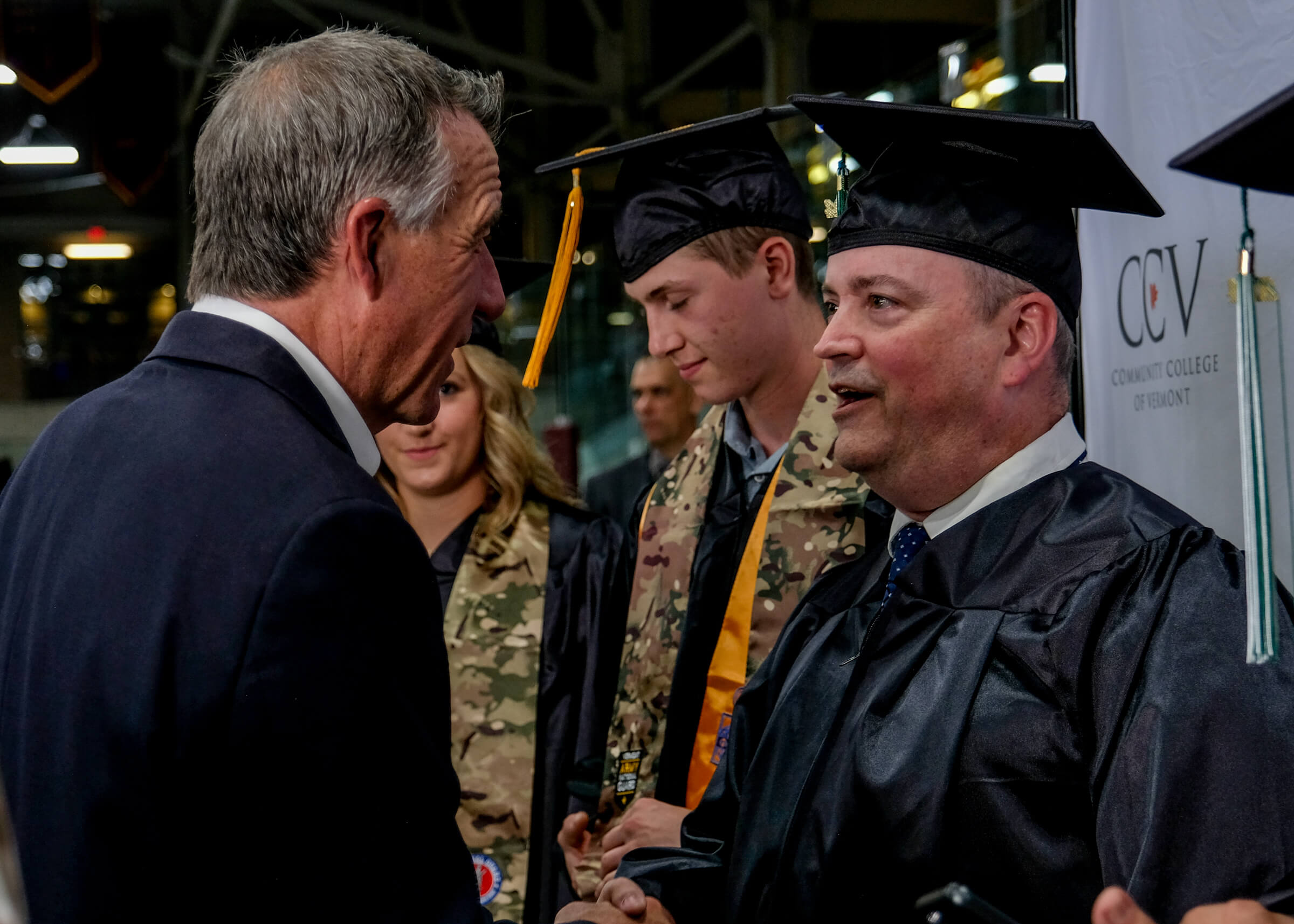 Governor Phil Scott talking with graduates
