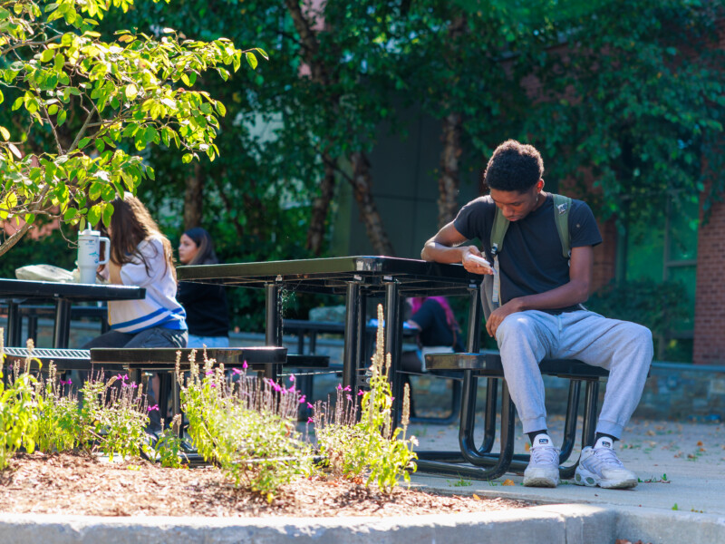 Student sitting at table outside
