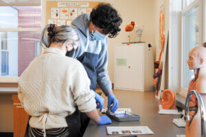 Two students doing a dissection in an anatomy and physiology lab.