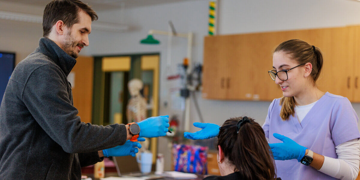 Three students in clinical medical assisting lab