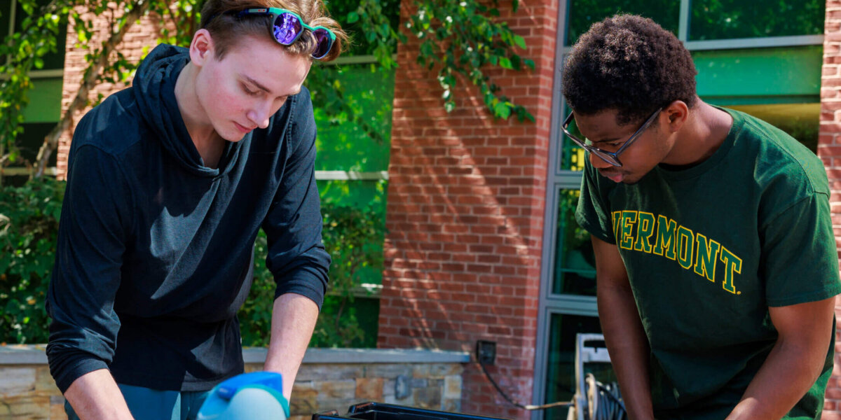 Two students working together outside CCV-Winooski.