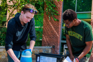 Two students working together outside CCV-Winooski.