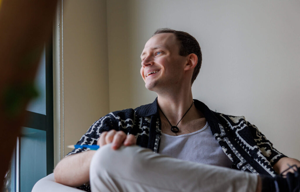 CCV alumnus Seamus Toler sitting in a chair looking out the window.