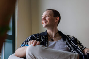 CCV alumnus Seamus Toler sitting in a chair looking out the window.