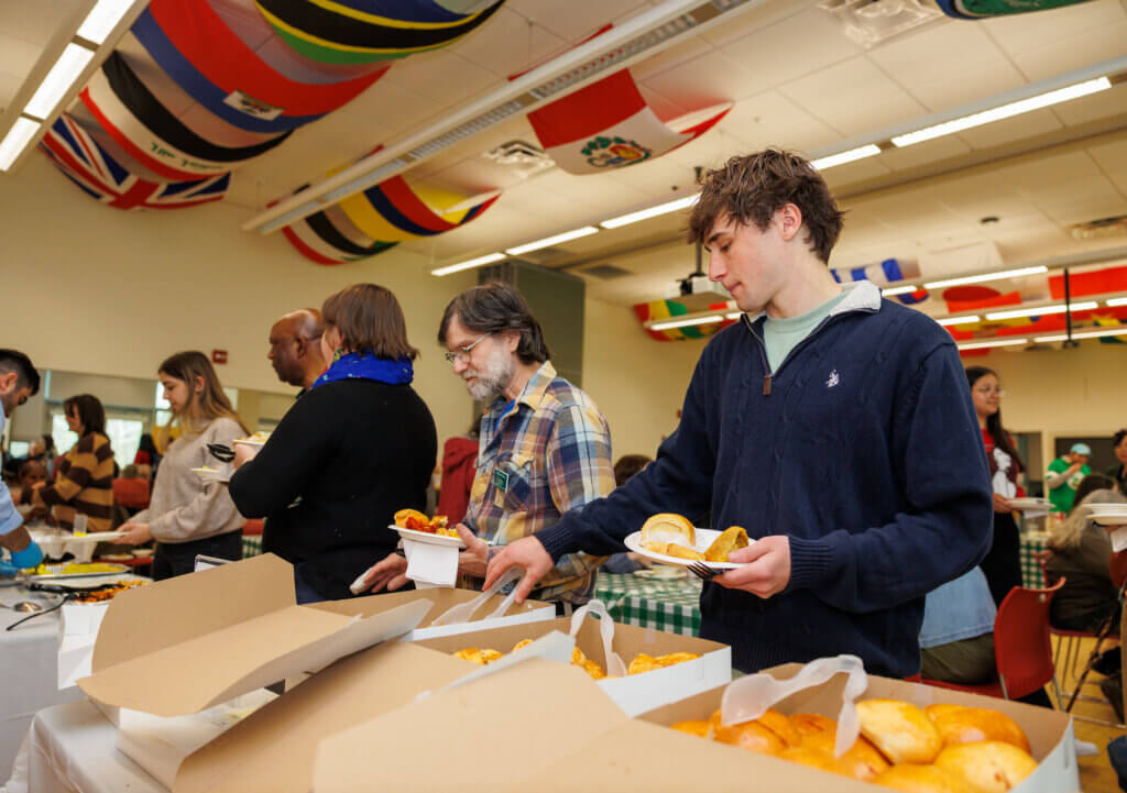 Students and faculty dishing up food at the International Food Festival.