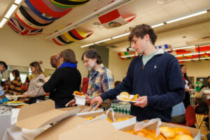 Students and faculty dishing up food at the International Food Festival.