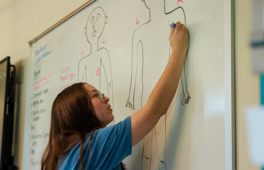 CCV student writing on a white board.