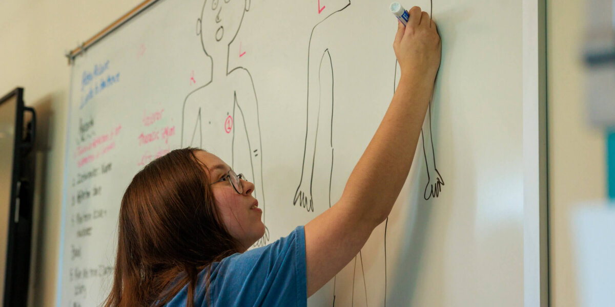 CCV student writing on a white board.