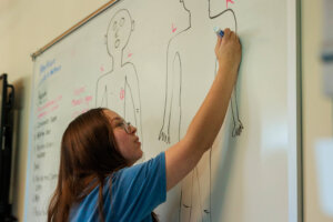 CCV student writing on a white board.